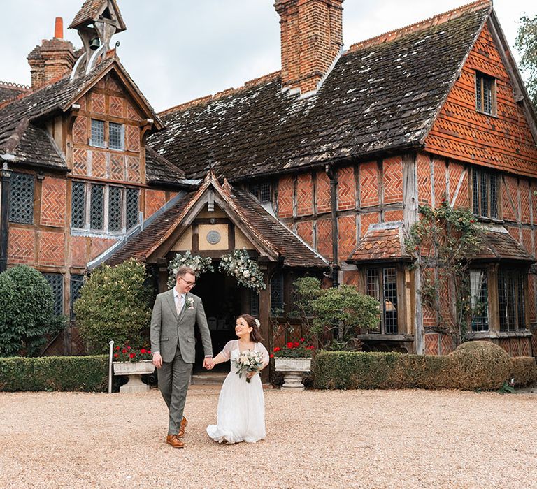 The bride and groom outside Langshott Manor wedding venue in Surrey 