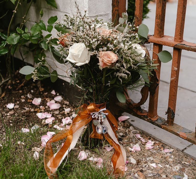 Autumnal wedding flower bouquet tied with ribbon and decorated with personal charms 