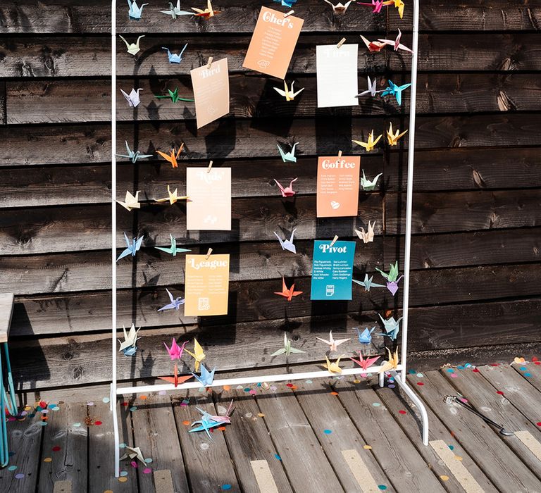 Colourful paper crane decorations on wedding table seating chart signage 