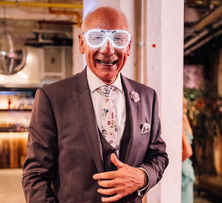 Father of the bride in a grey suit wearing funny light up sunglasses 