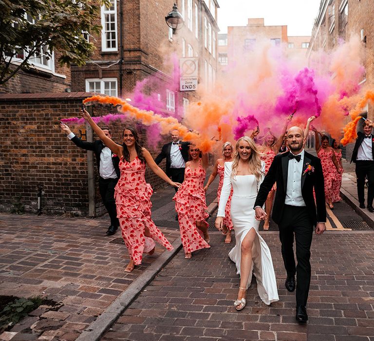 Pink and orange smoke flares held by wedding party for epic group photo at Shoreditch wedding 