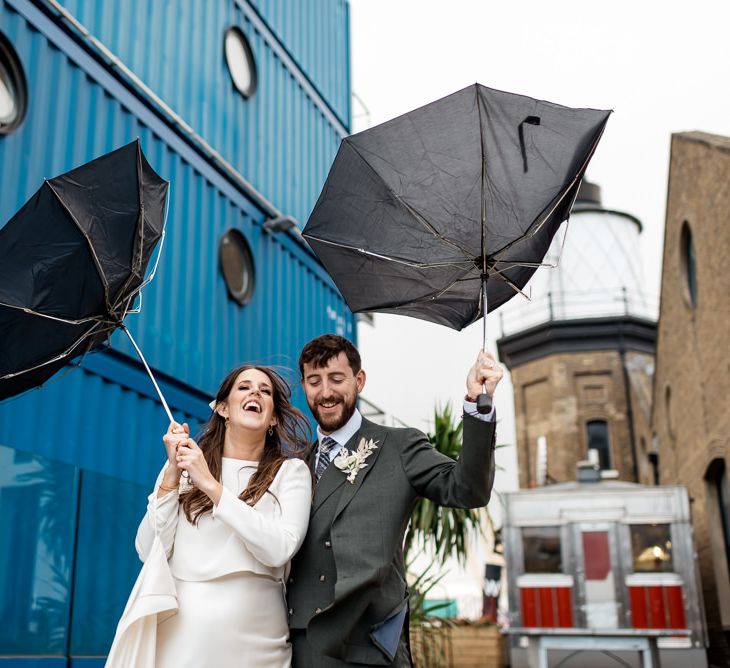 Bride and groom with inside out umbrellas at city wedding