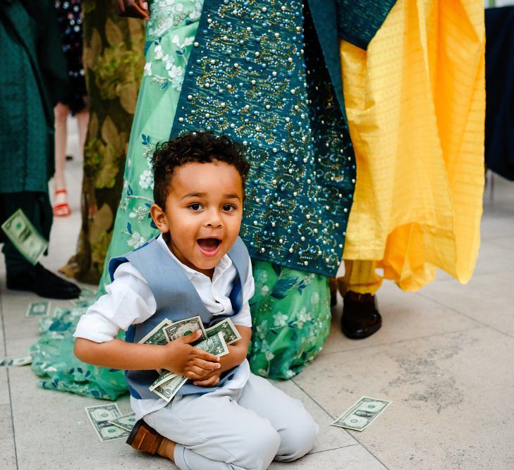 Little boy picking up the money at traditional Nigerian money dance 