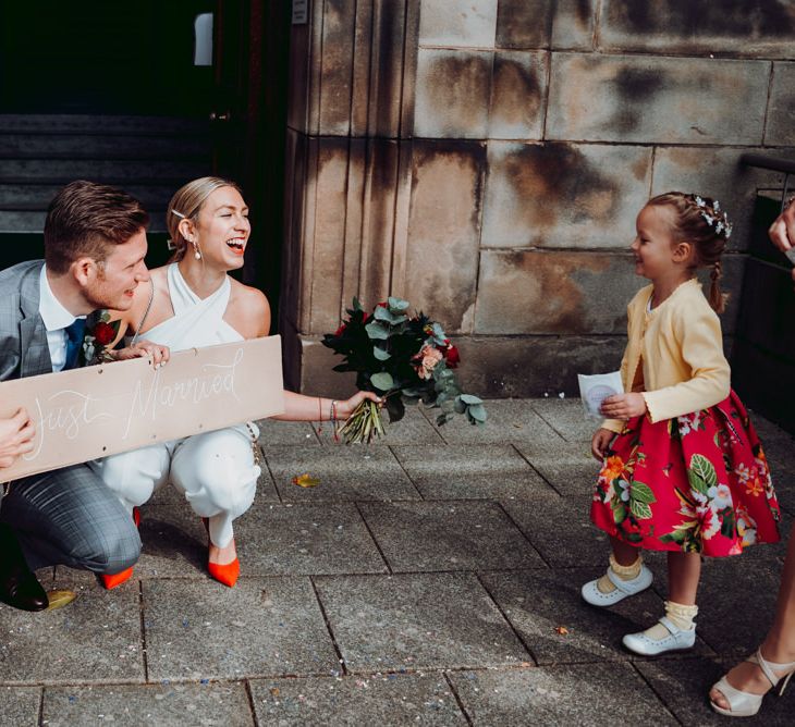 Bride and groom holding a DIY cardboard box 'just married' sign