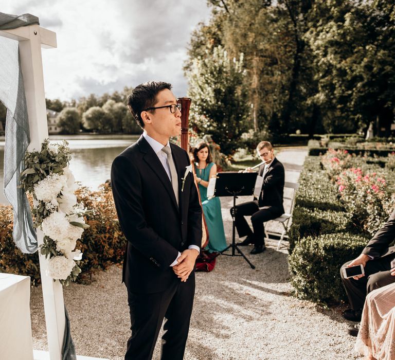 Groom standing at the altar in a dark suit