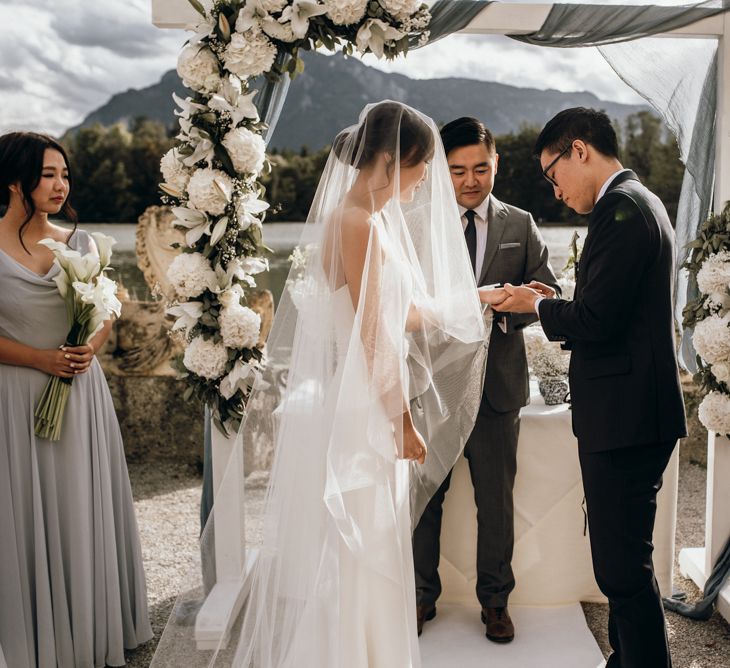 Bride and groom exchanging rings during the outdoor wedding ceremony 