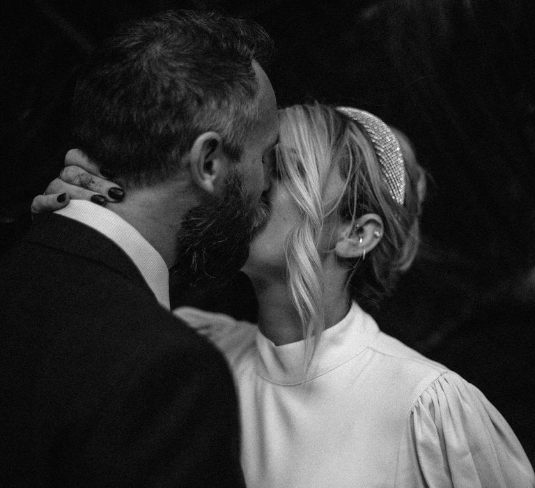 Black and white portrait of the bride and groom kissing 