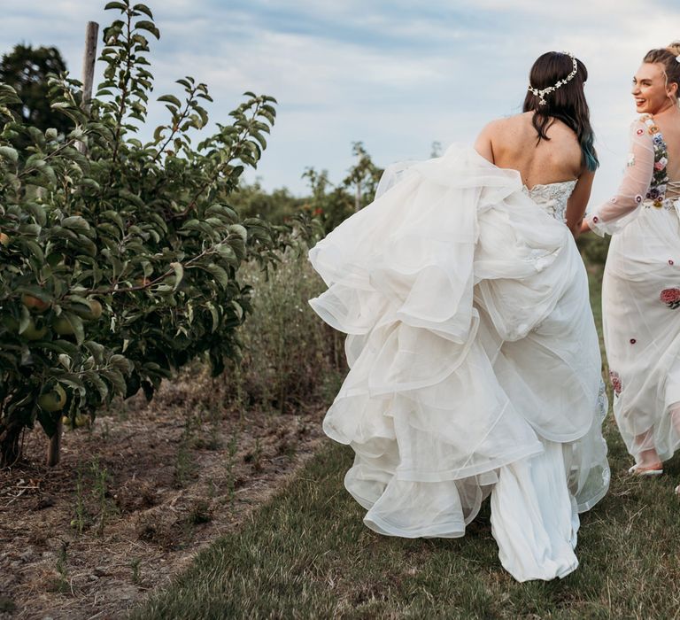 Same-sex couple dancing through the fields at The Cherry Barn