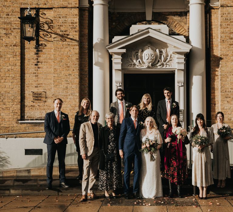 Bride & groom pose with wedding party after wedding ceremony