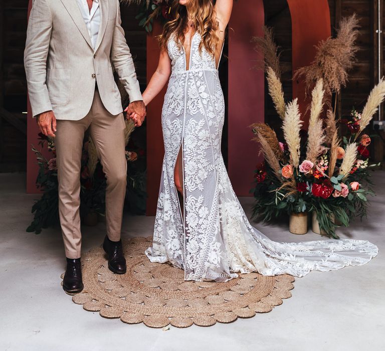 Bride celebrates in front of pink archway 