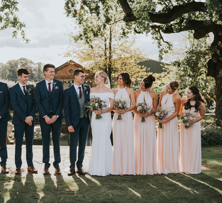 Bride & groom stand with their wedding party at either side of them