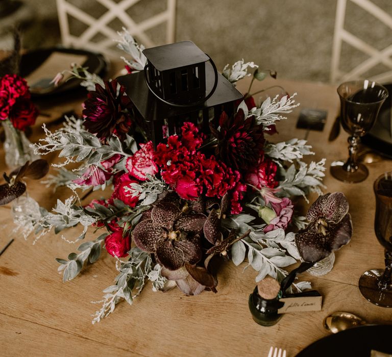 Black lantern and red flower centrepiece wedding decor 