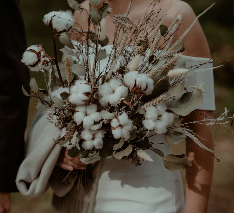 Bride carries dried floral bouquet 