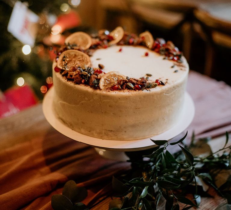 Wedding cake with lemon and pomegranate decor across top 