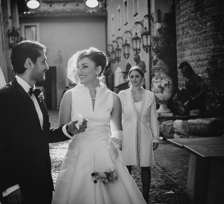 The bride and groom smiling hand in hand as they get married in Rome