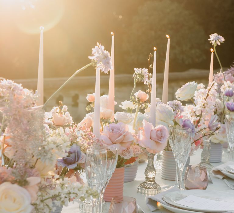 Golden hour tablescape image with white candles and pastel florals