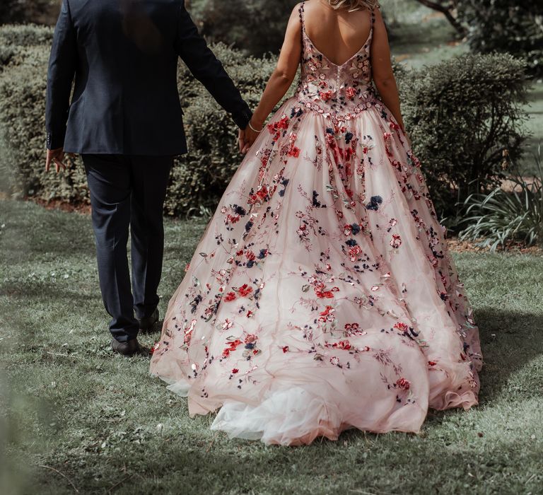 Bride & groom walk hand in hand on their wedding day