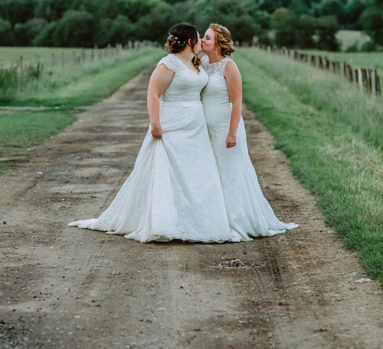 Lesbian brides stand together in the countryside for Park Farm wedding