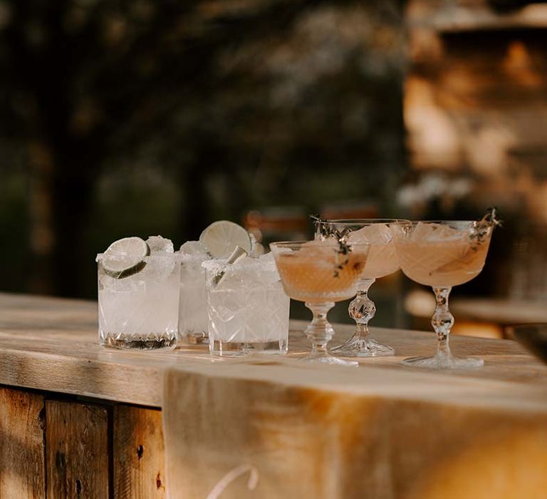 Mojito cocktails resting on the wooden bar in crystal cut glassware 