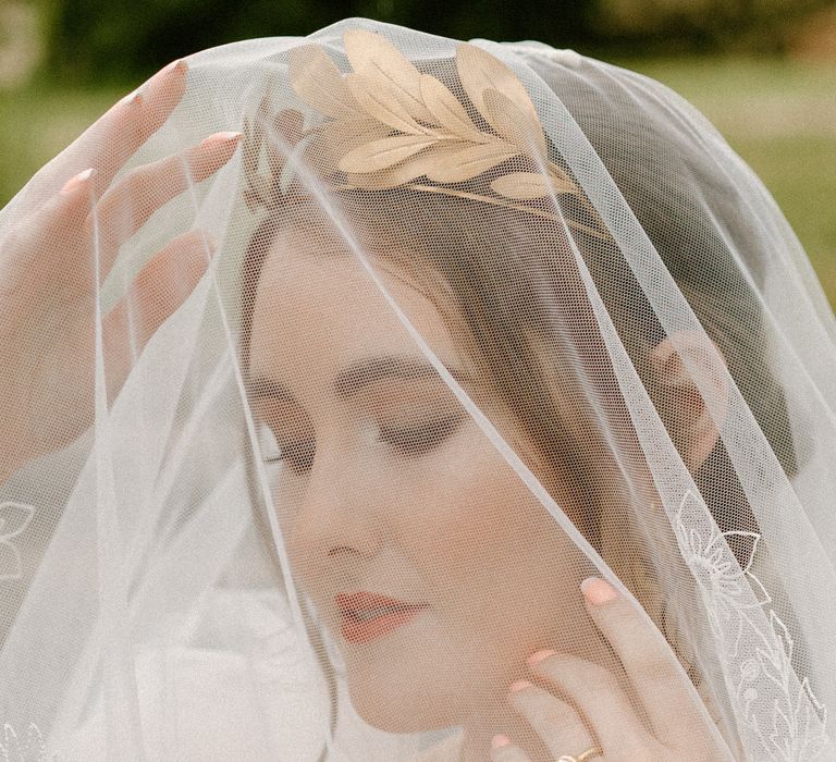 Beautiful bride with natural makeup wearing an embroidered wedding veil by Rebecca Anne Designs 