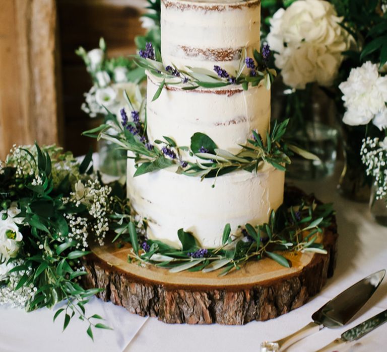 Semi naked wedding cake decorated with foliage and miniature Colin The Caterpillar chocolate cake toppers 