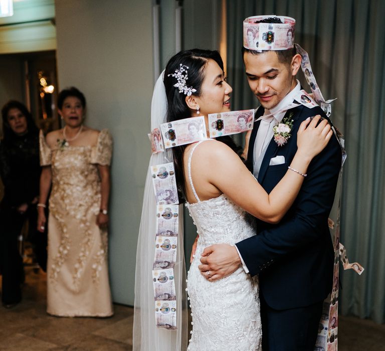 Money dance with south asian bride in a fitted embellished wedding dress and groom in a navy suit 