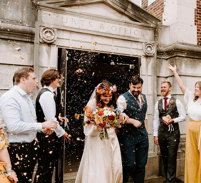 Bride & groom leave ceremony as wedding party throw confetti around them