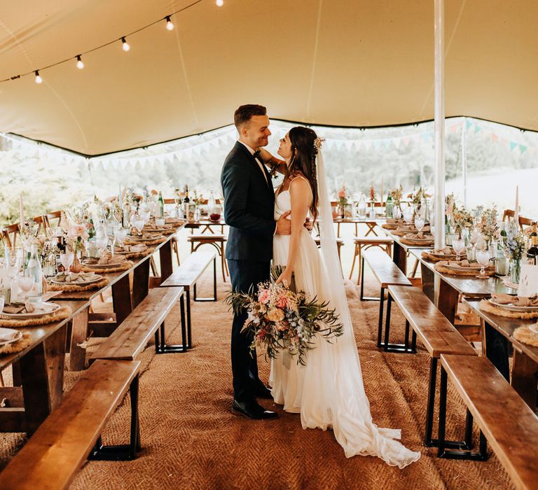 Stretch tent wedding reception at home with local suppliers and wildflower decor 