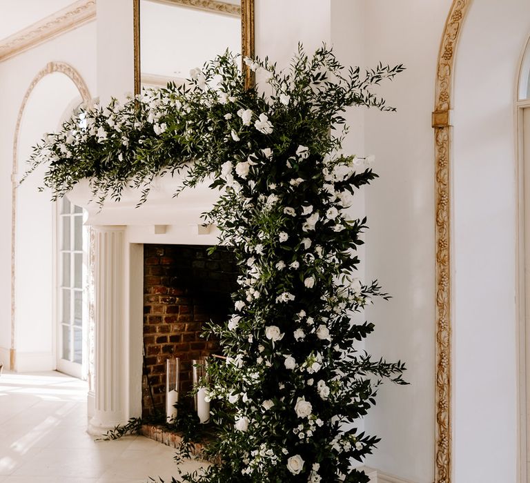 Green foliage and white flower fireplace wedding flowers at Northbrook Park wedding venue 