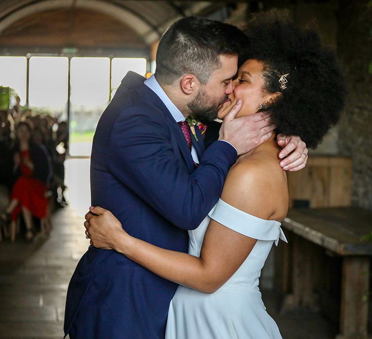 Bride & groom kiss after wedding ceremony