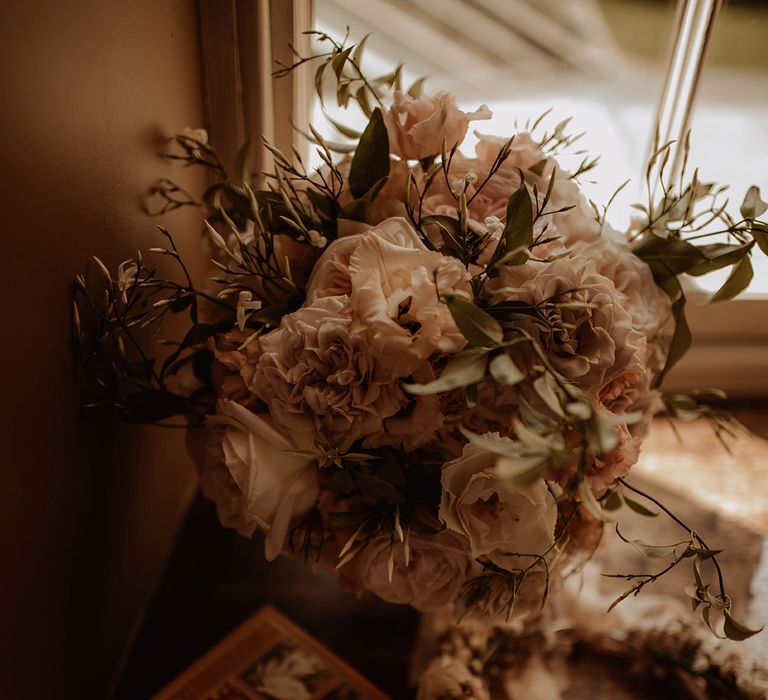 romantic pink wedding bouquet resting in the window 