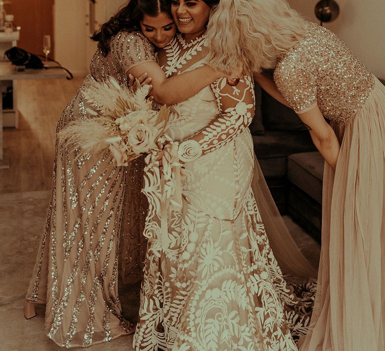 Bride on her wedding morning in a long sleeve wedding dress with her bridesmaids in sparkly bridesmaid dresses 