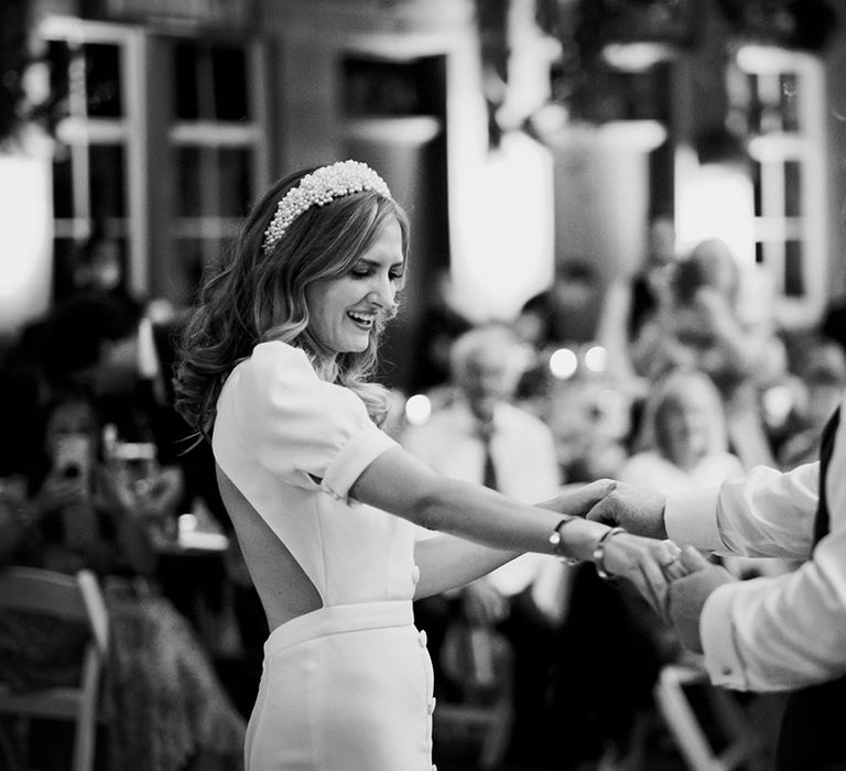 Bride in cutout back Bon Bride dress and pearl headband dances with groom in kilt