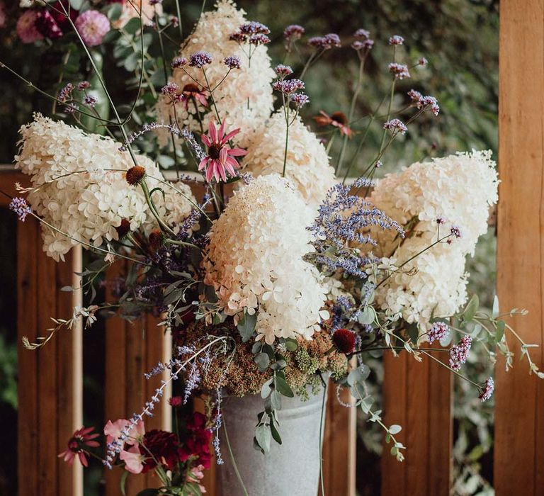 White, purple and pink wedding flowers for decor in metal bucket 