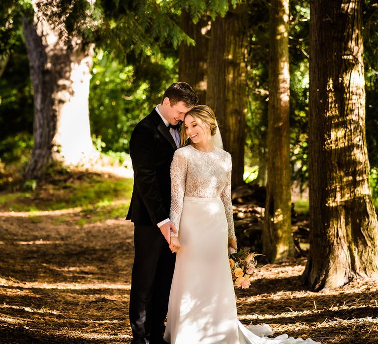 Bride and groom have their couple portraits in woodland area near their wedding venue at Hawkstone Hall