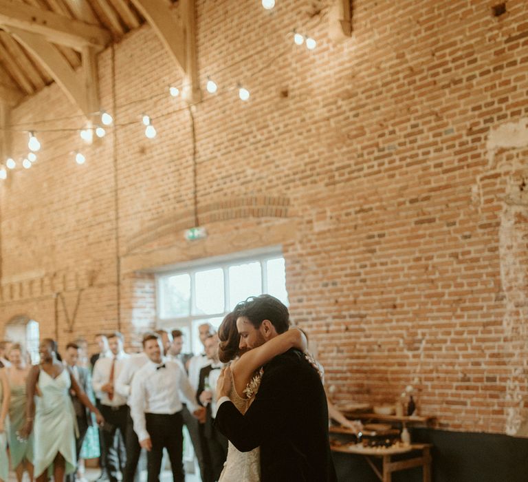 Bride and groom embrace as they have their first dance at Godwick Barn wedding venue