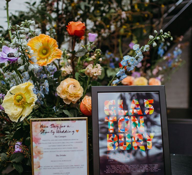 Bright spring flowers with Glastonbury festival poster and colourful menu sign 