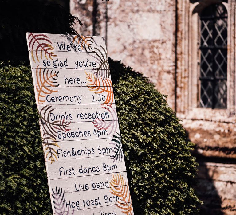 White painted wooden pallet order of the day wedding sign with colourful patterns 