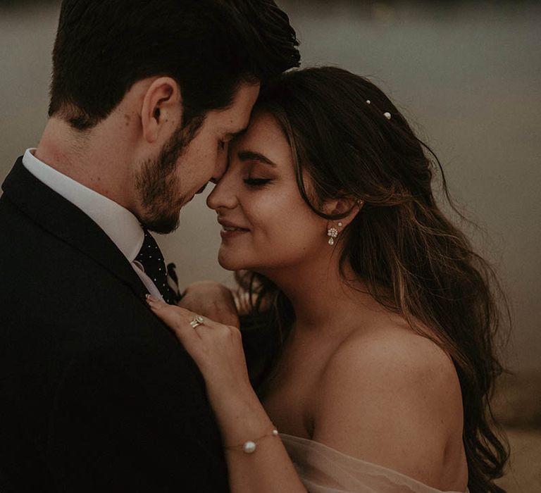 Bride with softly curled hair with pearl hair pins, pearl bracelet and earrings