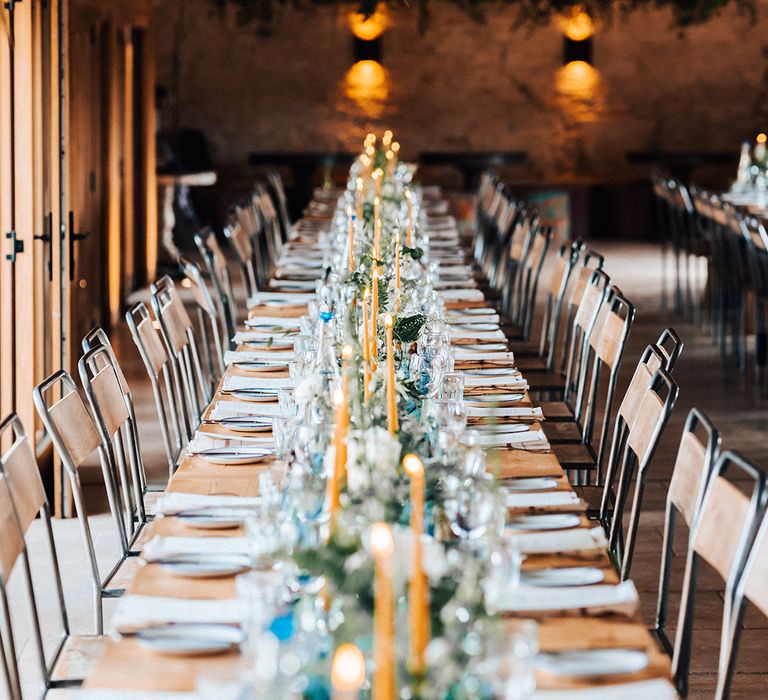 Rustic wedding reception table setting with blue and mustard decor colour scheme 