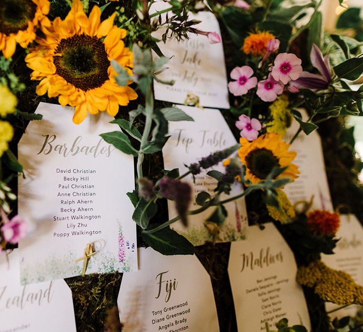 Moss and flower table plan complete with sunflowers and white stationery 