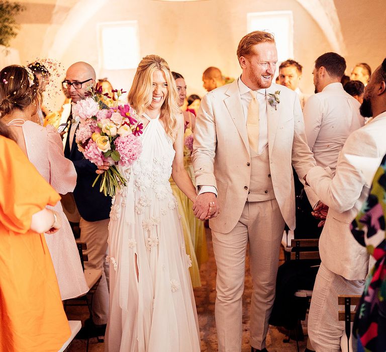 Bride and groom exit their wedding ceremony as a married couple 