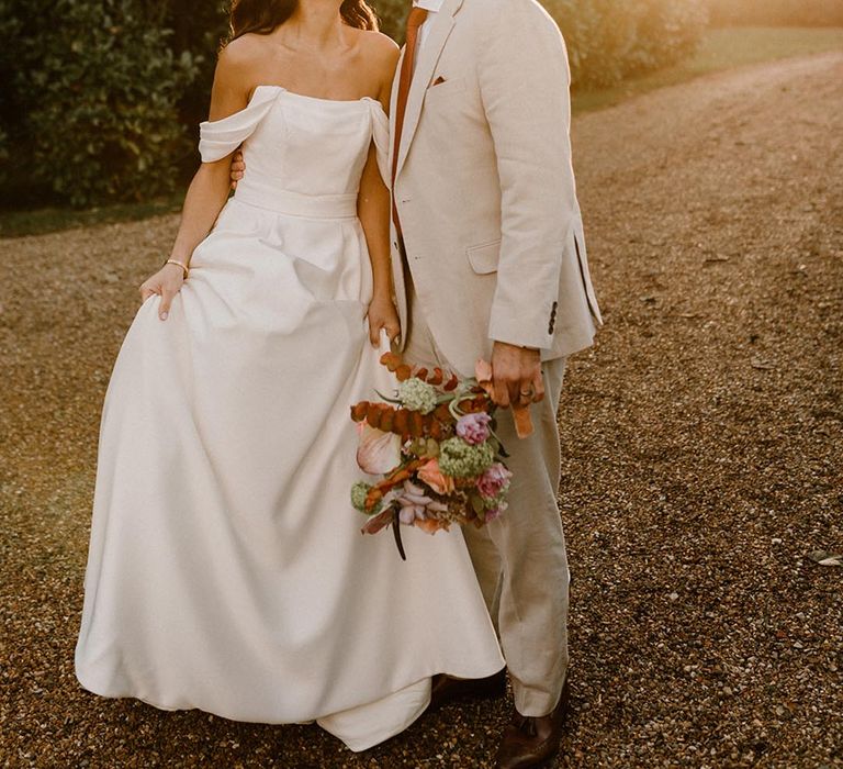 The sun starts setting and the golden light hits the bride and groom as they share a kiss 