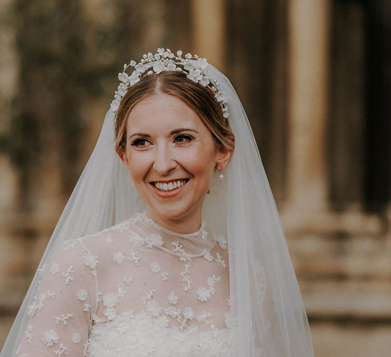 Bride wearing a white flower headband with pearl drop earrings for her traditional church wedding 