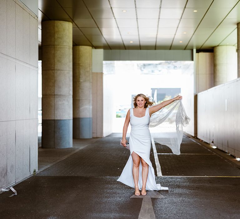 Bride wears fitted wedding dress with side split and pearl embellished cape 