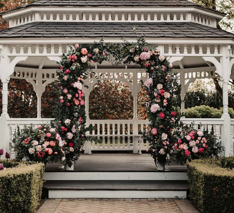 Pink flower arch with peonies and roses for outdoor ceremony to match the pink colour palette 