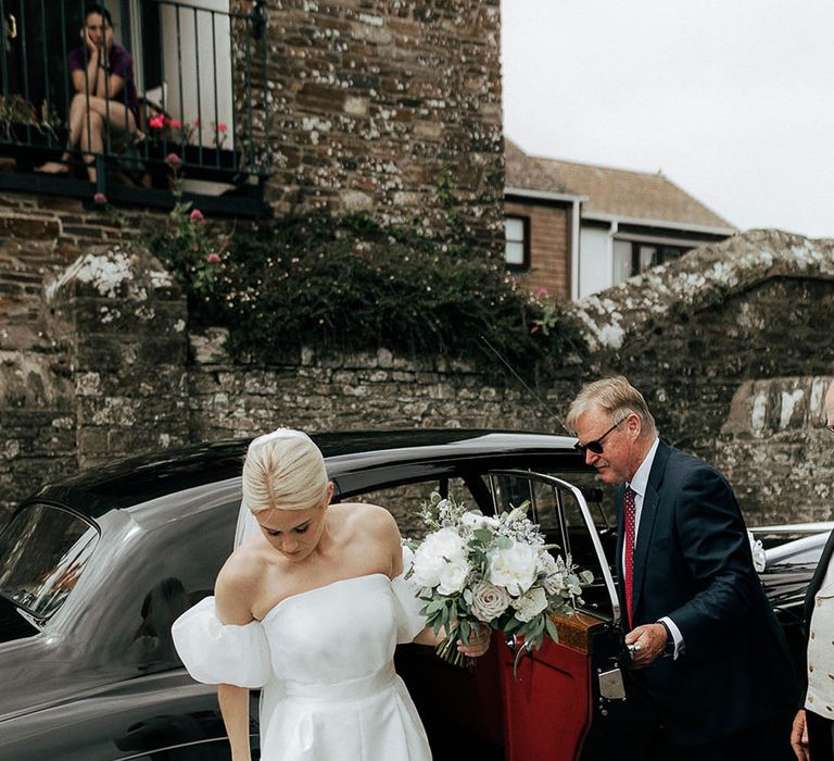 Bride wears Jesus Peiro wedding dress with puffed sleeves and holding bridal bouquet 