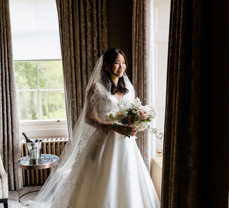 Bride wears Princess wedding dress complete with embellished waistband and cathedral veil