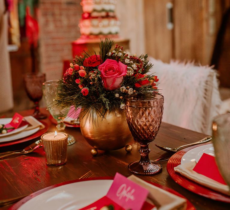 Wedding tablescape with hot pink plates, hot pink place names, gold candleholders and gold vase centrepieces