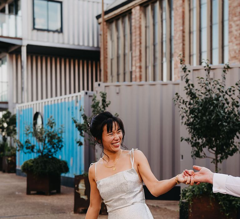 Bride wears silver The Vampire's Wife wedding dress with gold necklace 